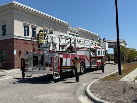 SJFD ladder truck and engine deployed at the Dosher Wellness Center with firefighters on the aerial platform