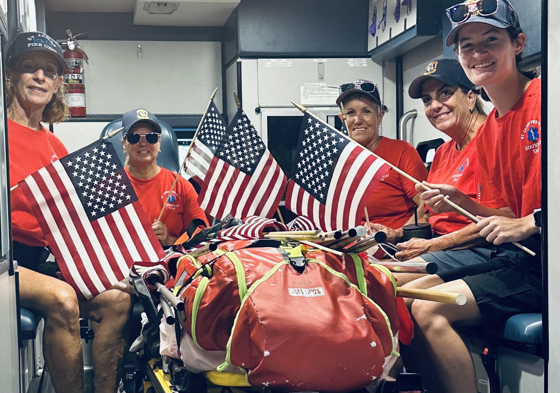 SJFD EMS volunteers inside the ambulance waving American flags during the parade