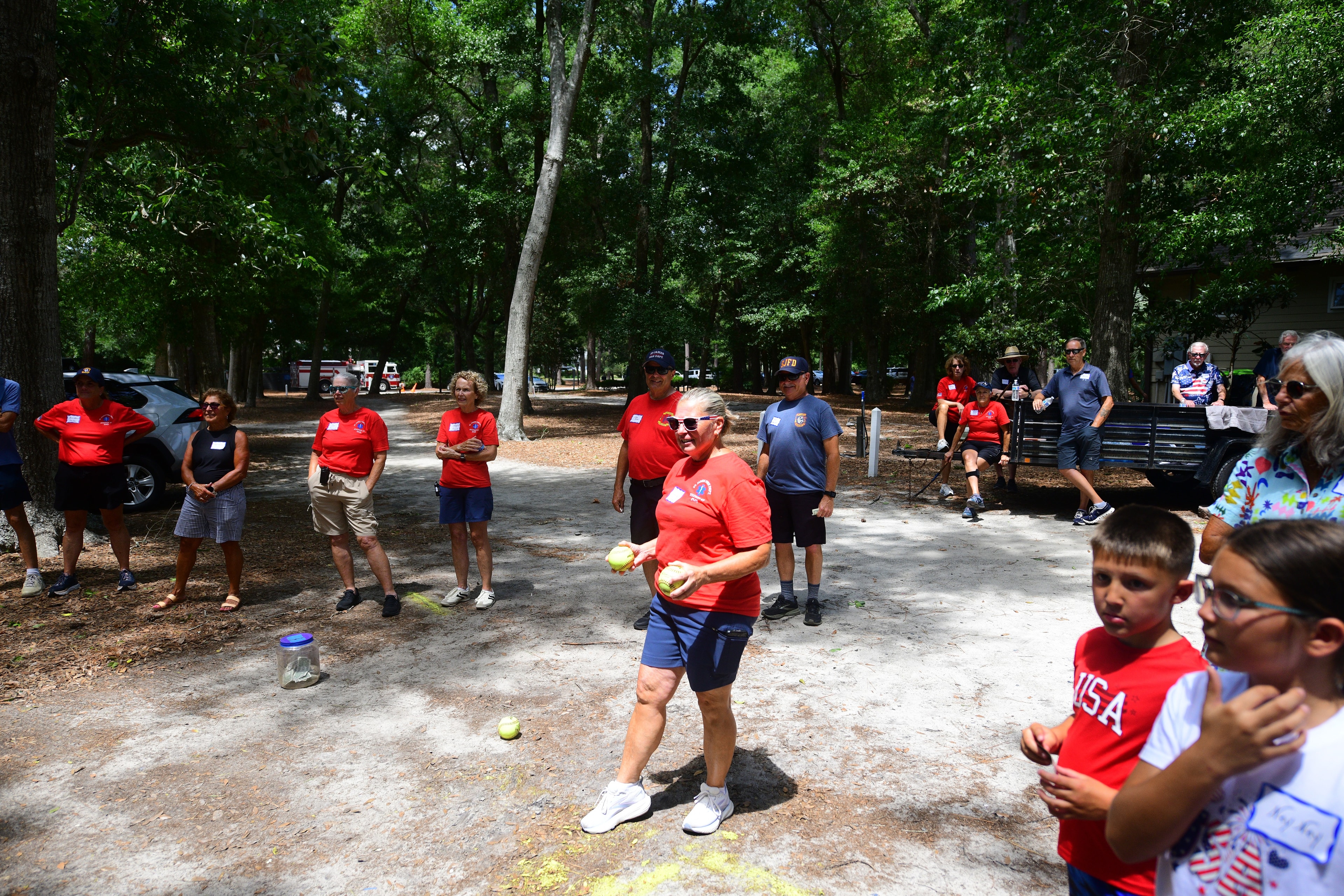 Volunteer winds up to throw a ball at the dunk tank during picnic games
