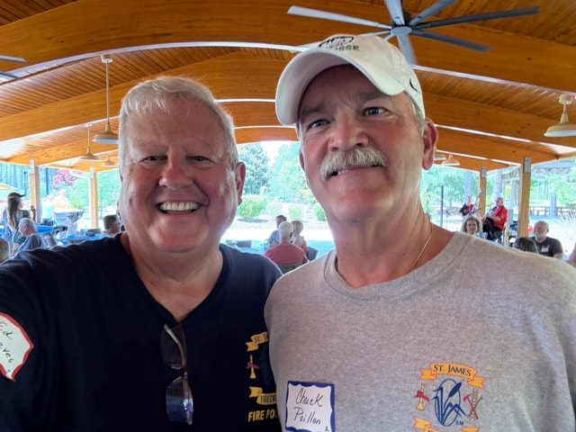 Two SJFD Fire Police volunteers including Chuck Paillon smile together at the picnic