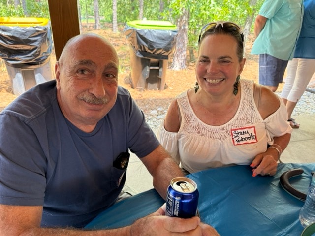 An SJFD volunteer and his guest laugh together at their picnic table