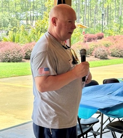 SJFD volunteer addresses the crowd at the picnic with a microphone