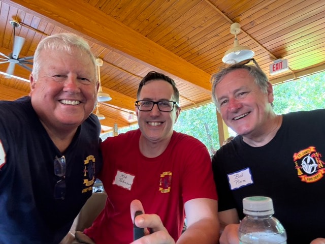 Three SJFD volunteers pose for a selfie under the pavilion