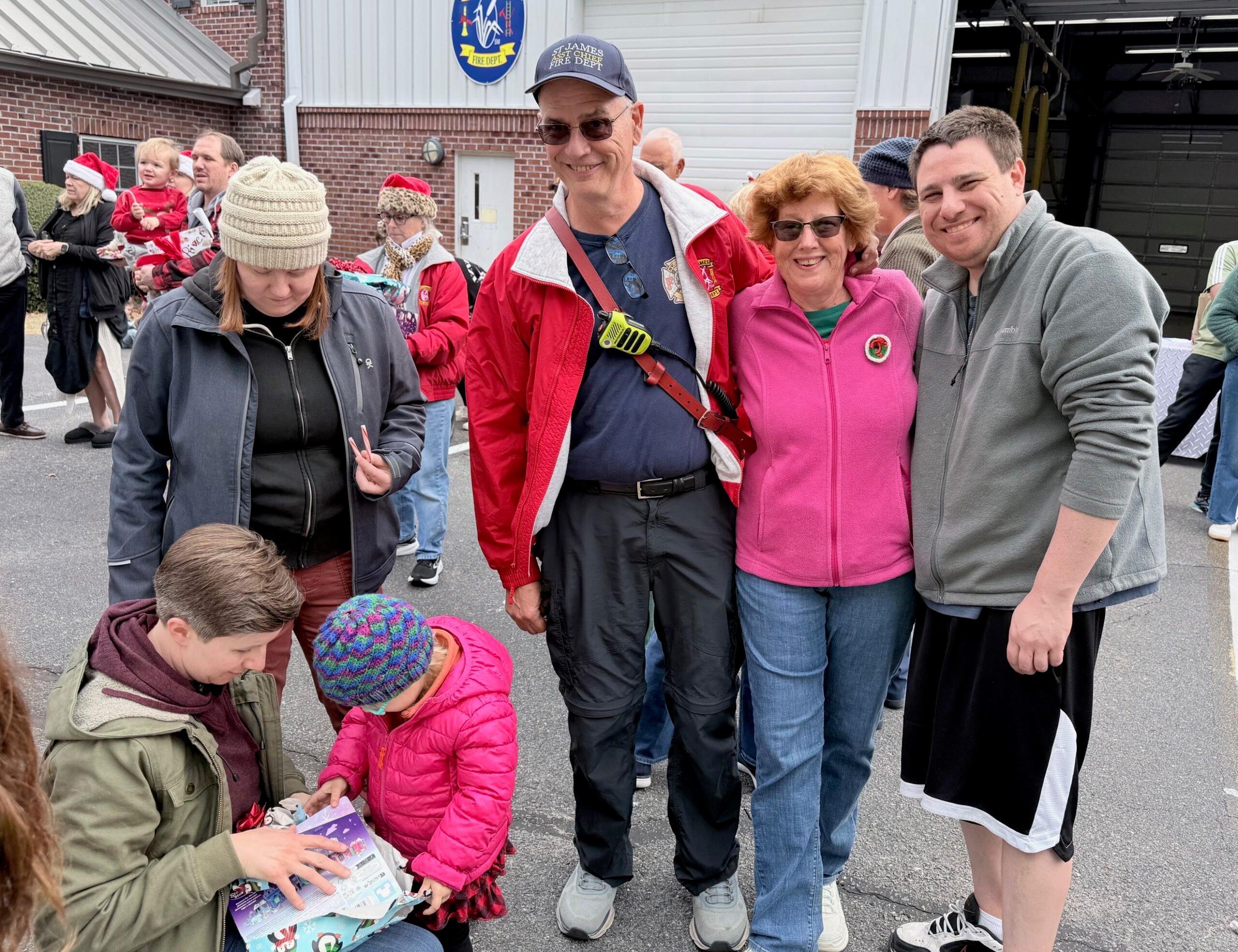 SJFD volunteer with family and community members outside the fire station during the Santa visit