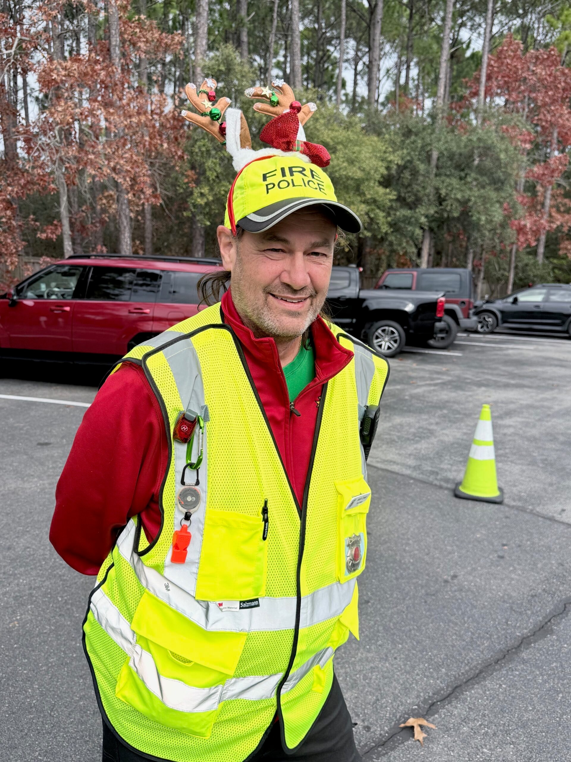 SJFD Fire Police volunteer Matt Crean in hi-vis vest and festive reindeer antlers directing traffic